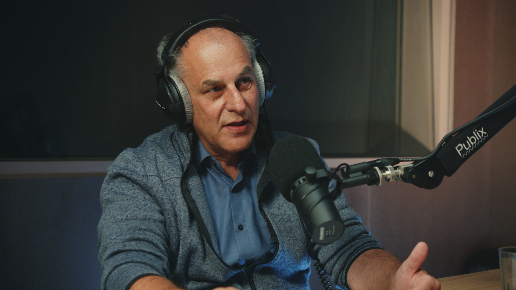 Ein Foto eines Mannes mit Kopfhörern im Podcast-Studio